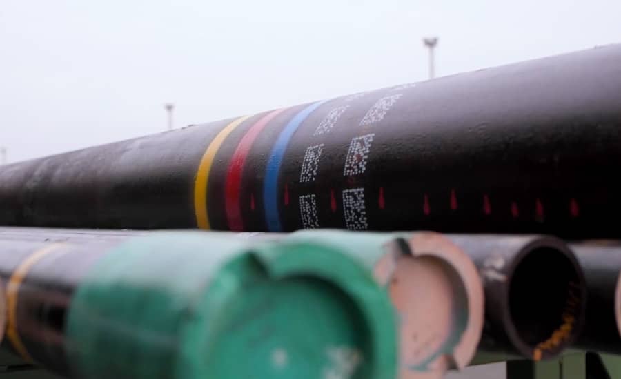 Tubi industriali impilati con codifica a colori e marcature stampate sulla superficie.